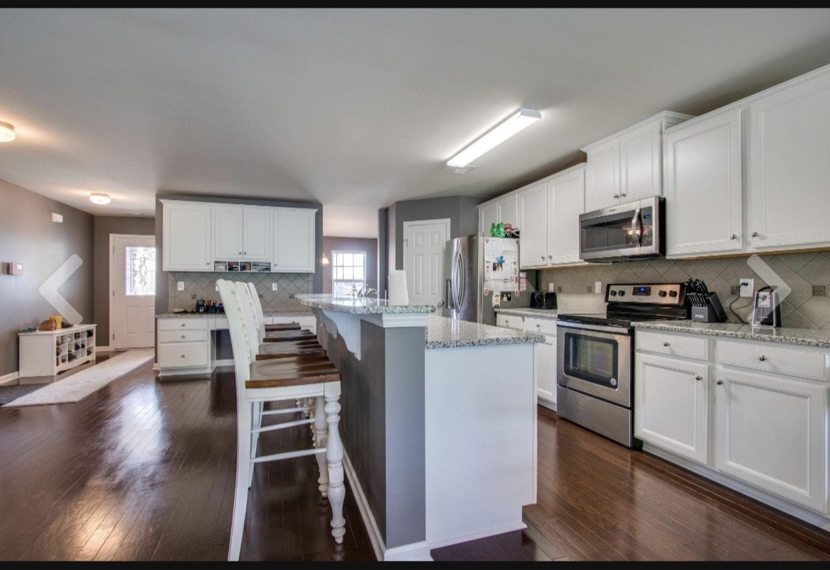 1470 Old Stone Road Lebanon, TN 37087 - Photo 8 of 23 a kitchen with stainless steel appliances kitchen island granite countertop a stove top oven a sink a refrigerator and white cabinets with wooden floor