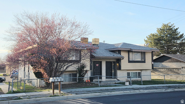 8404 Monroe Street Midvale, UT 84047 - Photo 1 of 1 View of front of house with brick siding, a fenced front yard, and a chimney