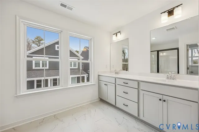 a spacious bathroom with double sink and a large mirror