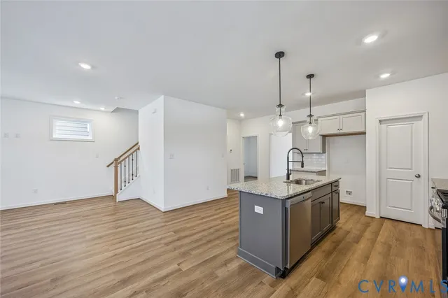 a kitchen with stainless steel appliances granite countertop a stove and a wooden floor