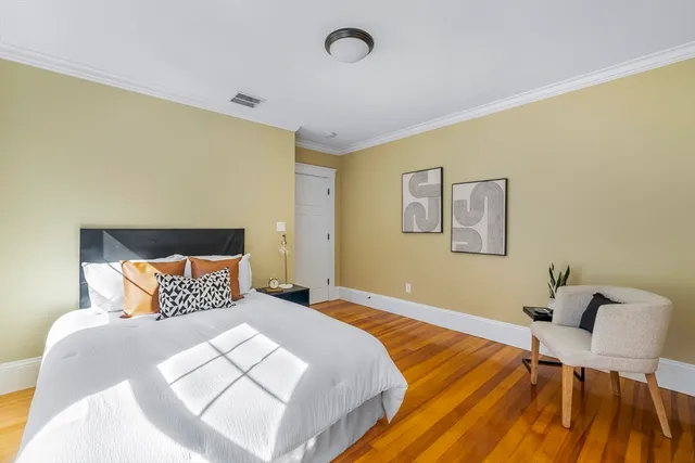 a bedroom with a bed and wooden floor
