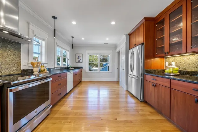 a large kitchen with stainless steel appliances granite countertop a large stove top oven and a refrigerator