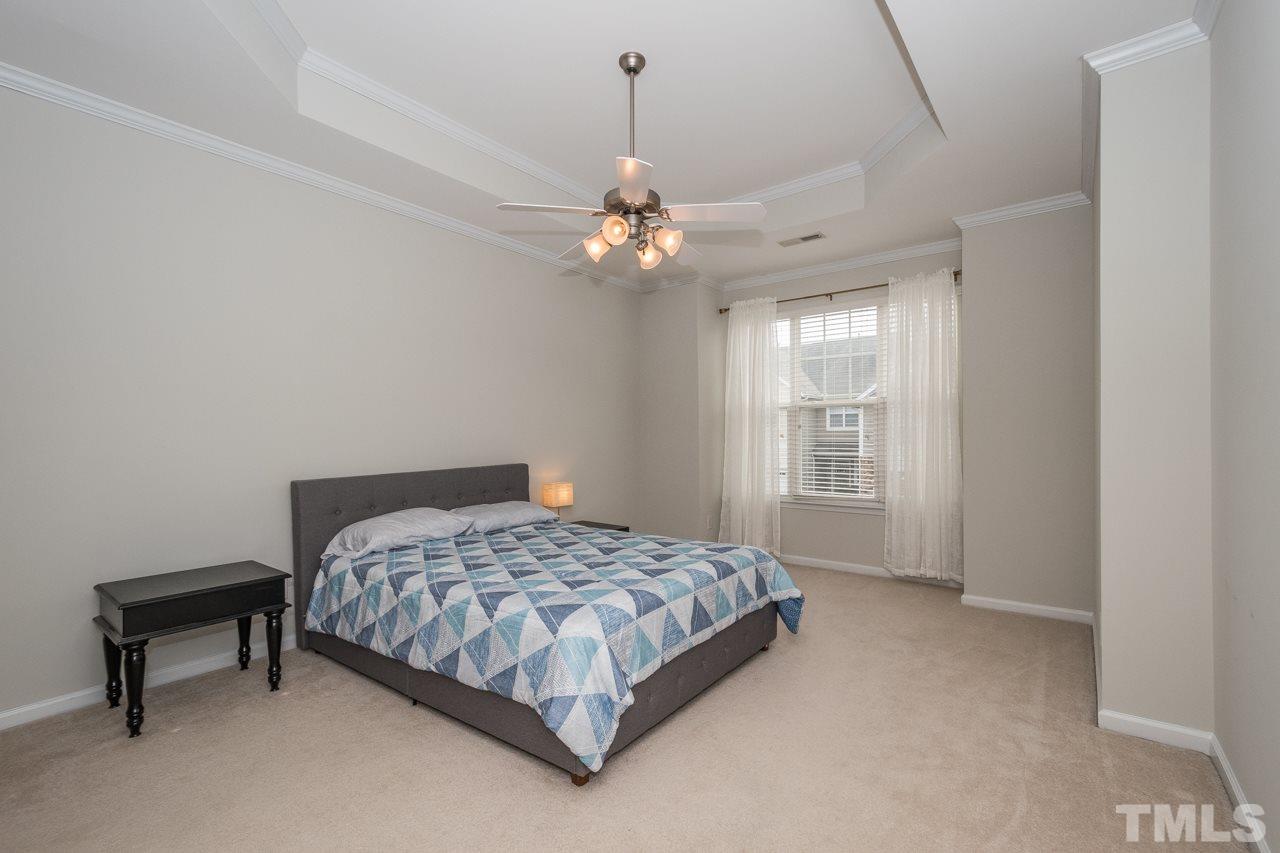 4924 Amber Clay Lane Raleigh, NC 27612 - Photo 17 of 24 a bedroom with a bed chandelier and a window