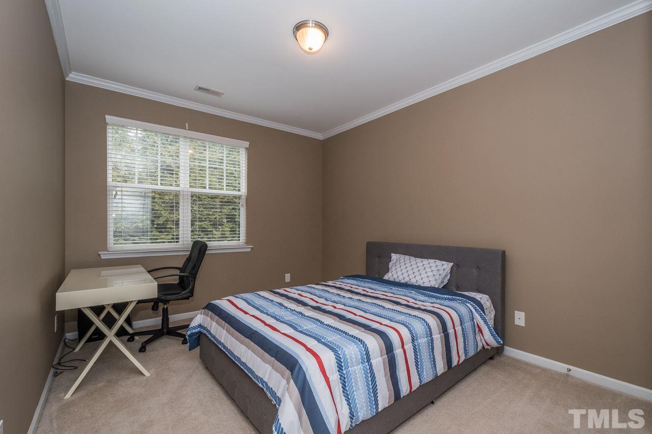 4924 Amber Clay Lane Raleigh, NC 27612 - Photo 20 of 24 a bedroom with a bed and a desk