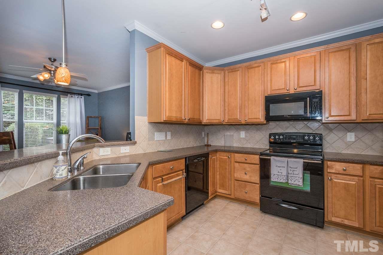 4924 Amber Clay Lane Raleigh, NC 27612 - Photo 8 of 24 a kitchen with stainless steel appliances granite countertop a sink a stove and a microwave