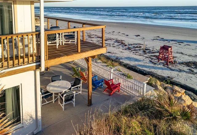 an aerial view of a house with large trees and buildings