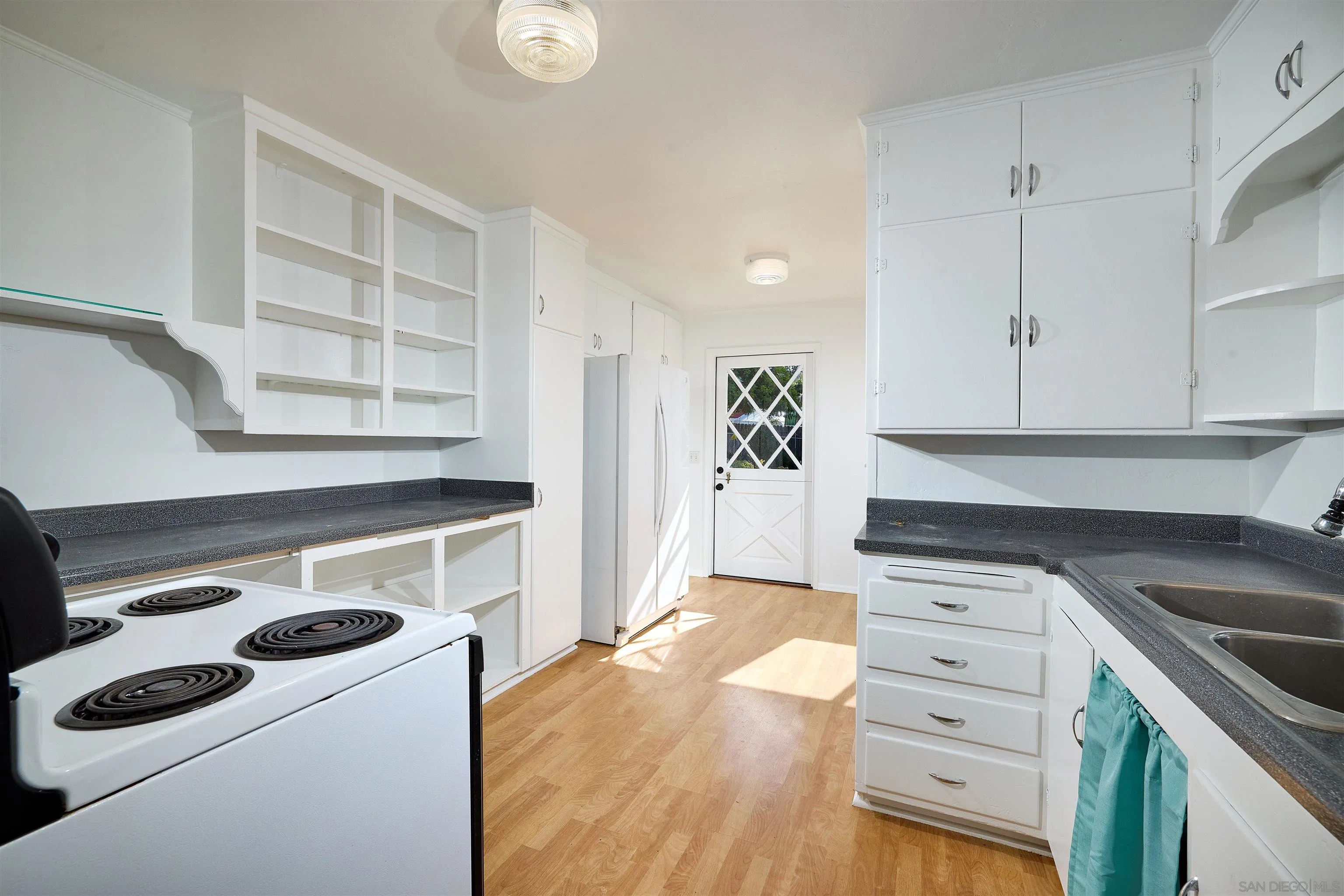 208 Avalon Drive Vista, CA 92084 - Photo 12 of 30 a kitchen with a stove cabinets and wooden floor