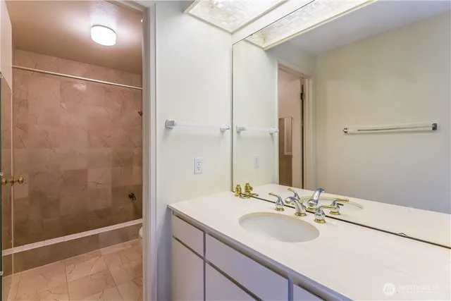 a bathroom with a sink shower and a mirror