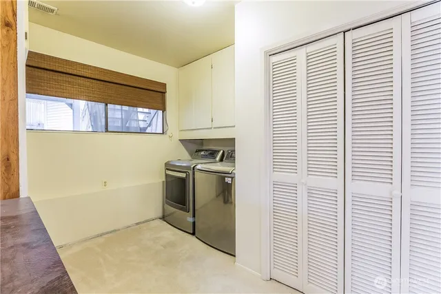a kitchen with a refrigerator and white cabinets