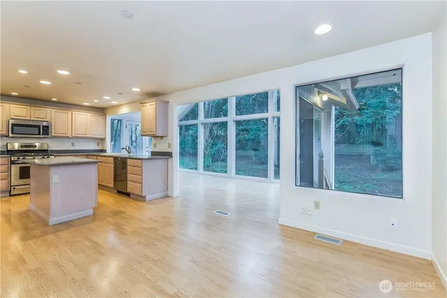 a open kitchen with stainless steel appliances granite countertop a refrigerator a sink a stove and a wooden cabinets