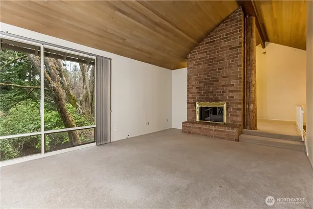 a view of an empty room with a fireplace and a window