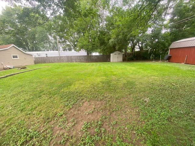 a view of a house with a backyard and a tree