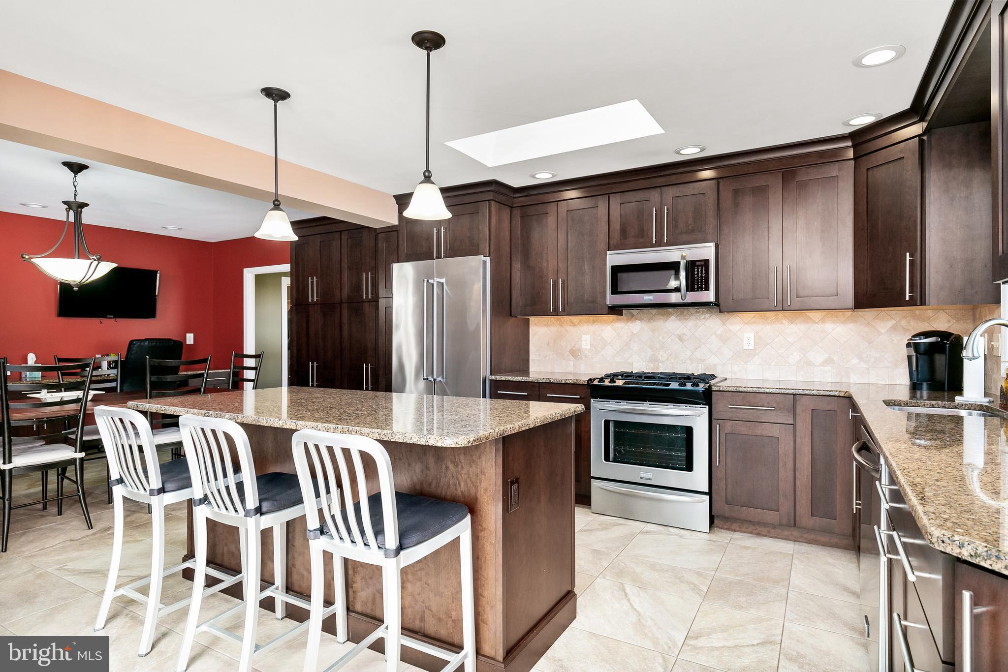 16 Vicksburg Road Laurel Springs, NJ 08021 - Photo 10 of 31 a kitchen with stainless steel appliances granite countertop a stove top oven a sink dishwasher a dining table and chairs with wooden floor