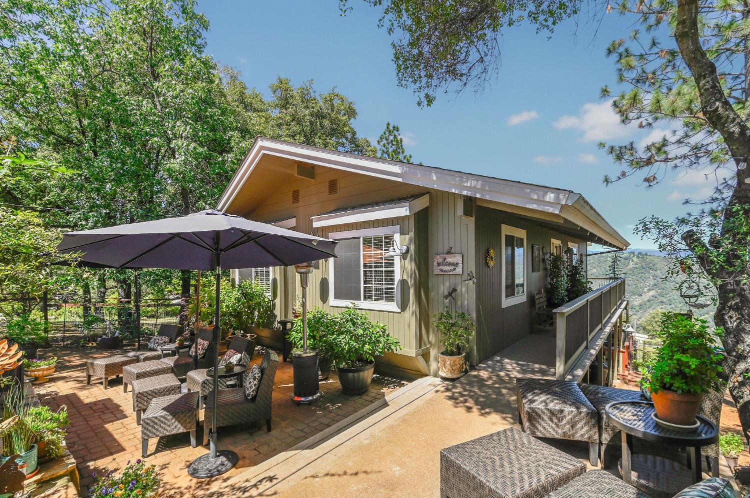 11266 Clinton Bar Road Pine Grove, CA 95665 - Photo 2 of 77 a view of a patio with table and chairs under an umbrella