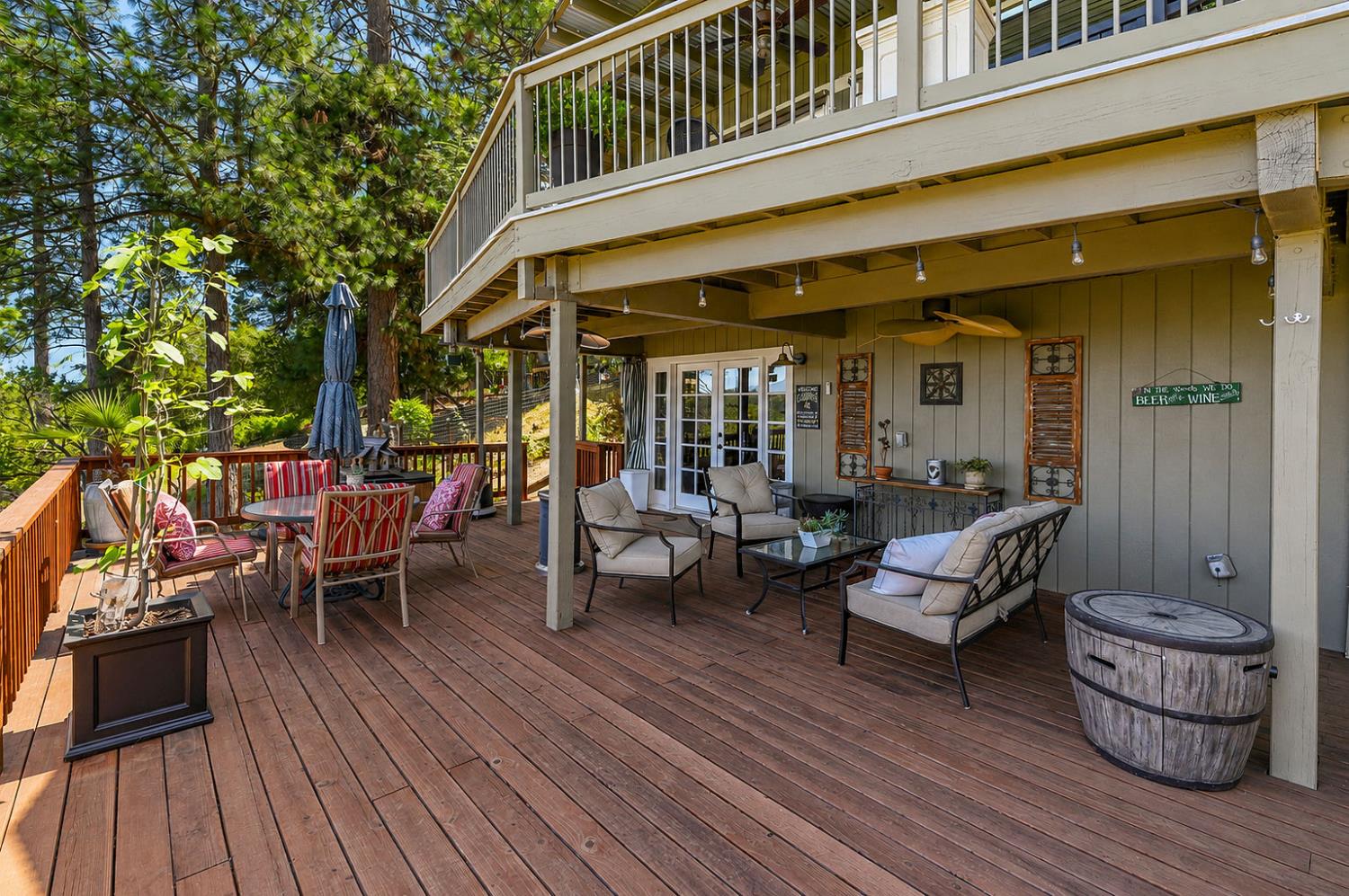 11266 Clinton Bar Road Pine Grove, CA 95665 - Photo 37 of 77 a view of a patio with couches and table and chairs with wooden floor and fence