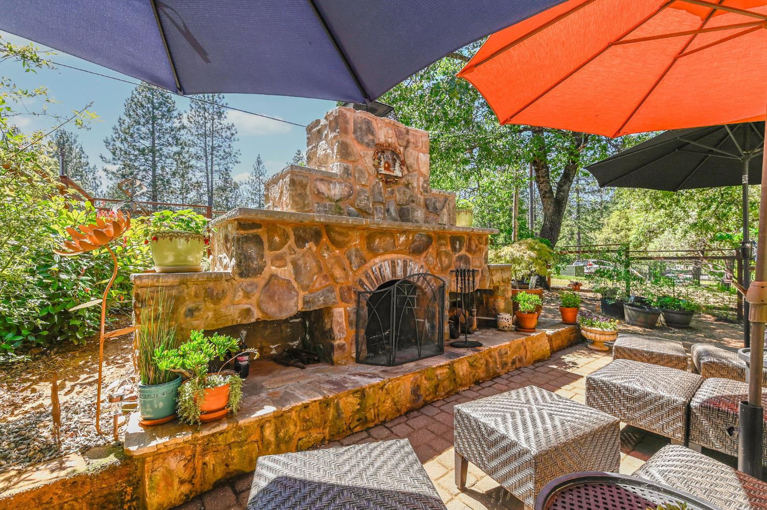 11266 Clinton Bar Road Pine Grove, CA 95665 - Photo 73 of 77 a view of a patio with couches table and chairs under an umbrella