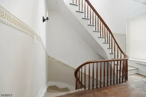 a view of staircase with railing and white walls