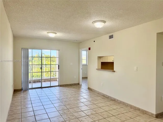 a view of an empty room with window and cabinet