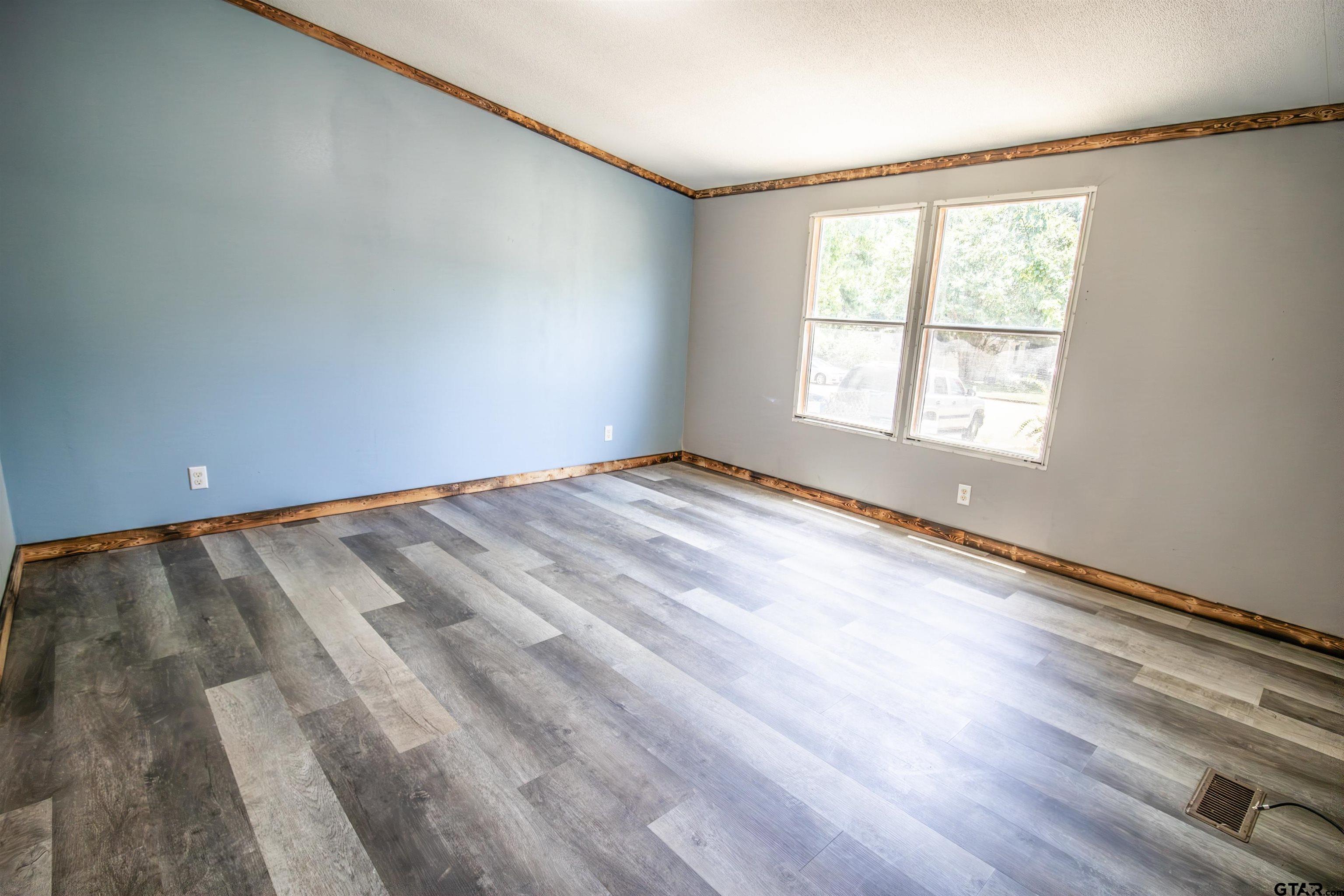 12450 Fannin Parkway Tyler, TX 75708 - Photo 17 of 39 a view of an empty room with wooden floor and a window