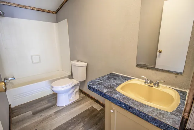 a bathroom with a granite countertop sink toilet and a mirror