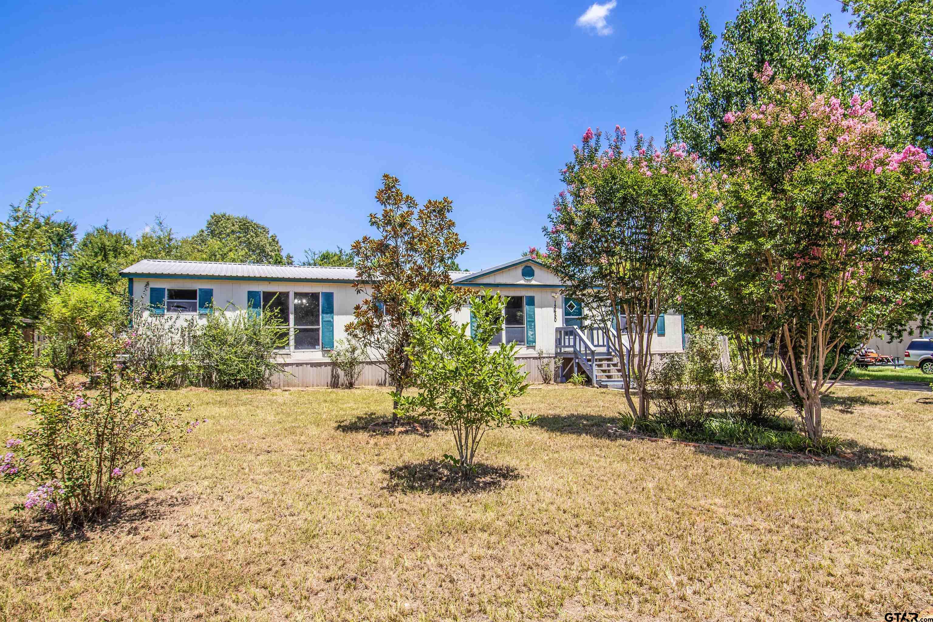 12450 Fannin Parkway Tyler, TX 75708 - Photo 3 of 39 a front view of a house with a yard and potted plants