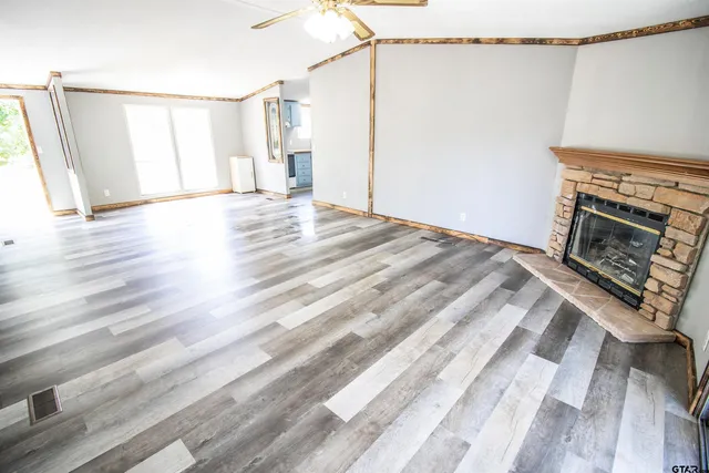 a view of empty room with wooden floor and fireplace