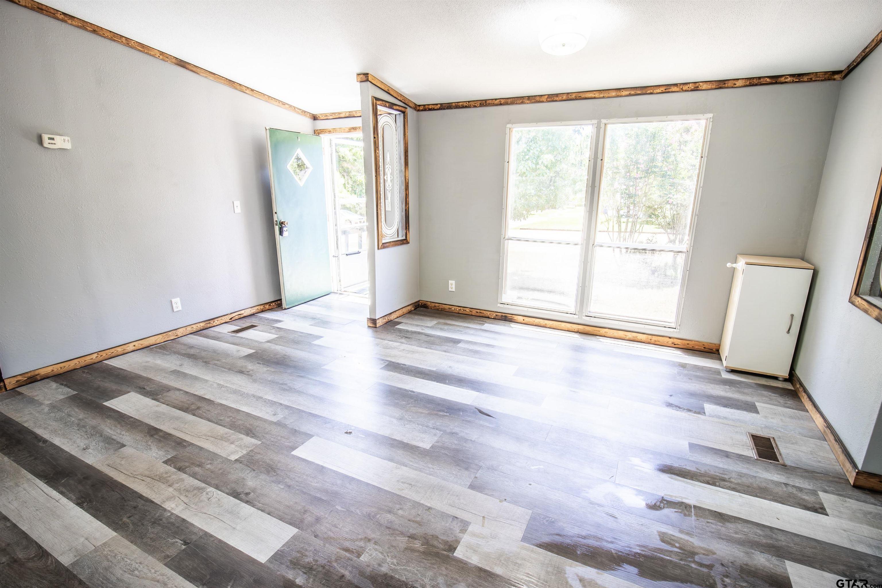 12450 Fannin Parkway Tyler, TX 75708 - Photo 8 of 39 a view of an empty room with a window and wooden floor