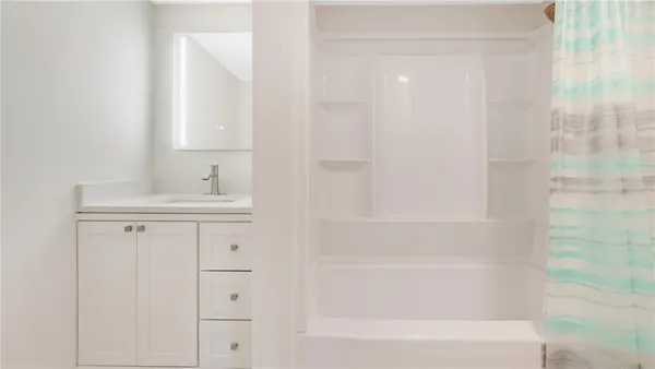 a bathroom with a bathtub sink vanity and a shower