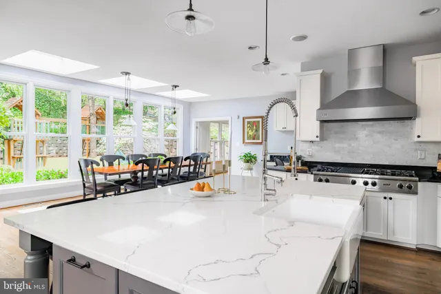 a kitchen with stainless steel appliances a stove a sink and a large window