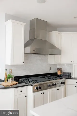 a kitchen with granite countertop a sink a stove and cabinets