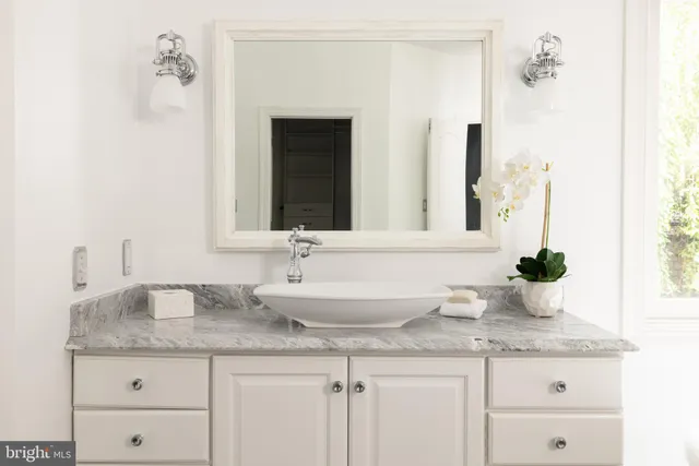 a bathroom with a granite countertop sink and a mirror