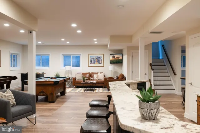 a living room with furniture kitchen view and a potted plant