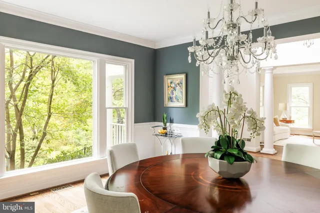 a dining room with furniture wooden floor a chandelier and a rug