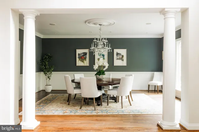 a dining room with wooden floor a chandelier a wooden table and chairs