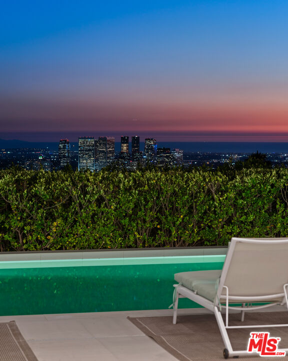 1115 Wallace Ridge Beverly Hills, CA 90210 - Photo 16 of 18 a view of a street with a bench in front of the house