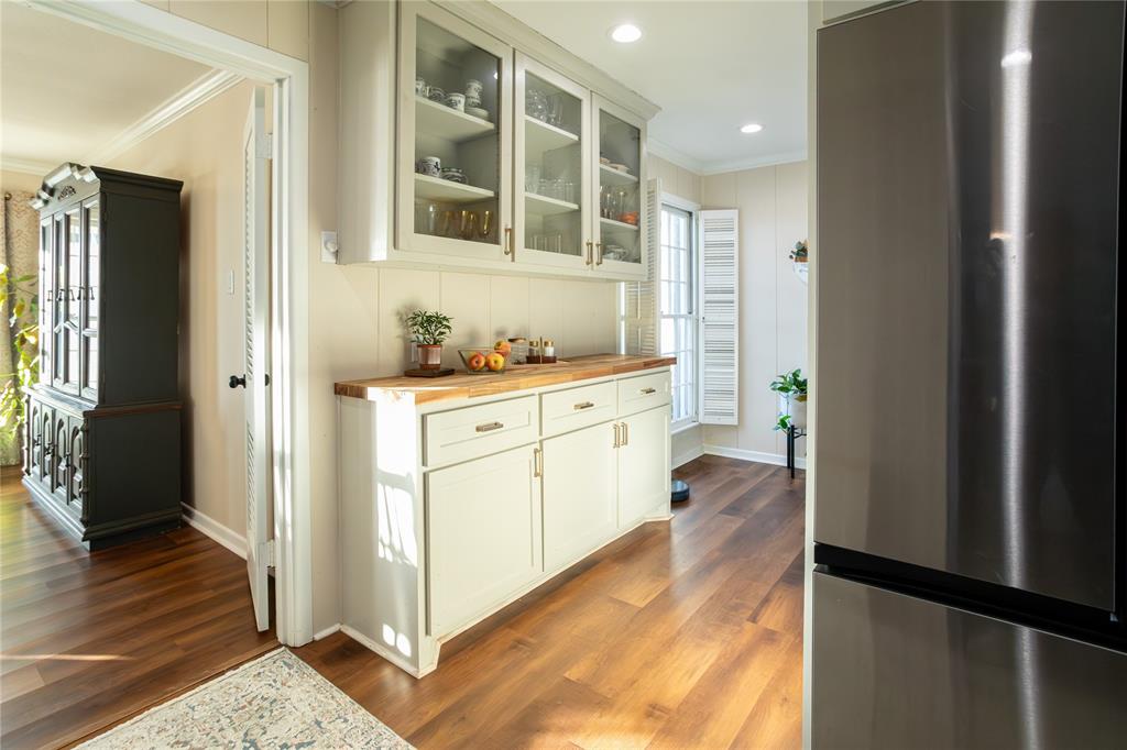 909 Cherry Street Baird, TX 79504 - Photo 14 of 32 a hallway with cabinets and wooden floor