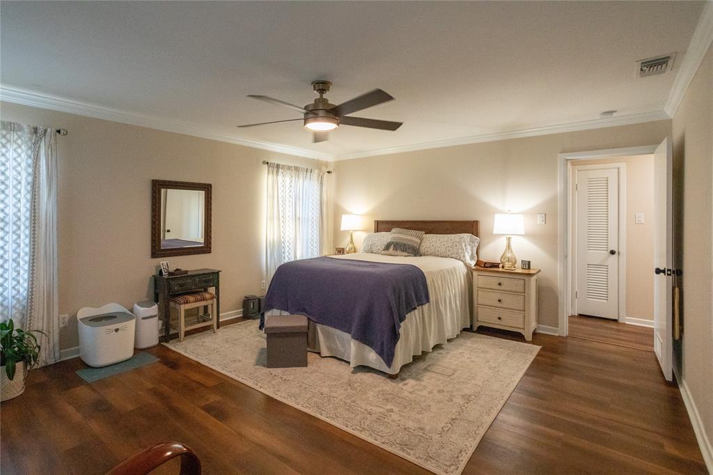 909 Cherry Street Baird, TX 79504 - Photo 15 of 32 a bedroom with a large bed and a chandelier