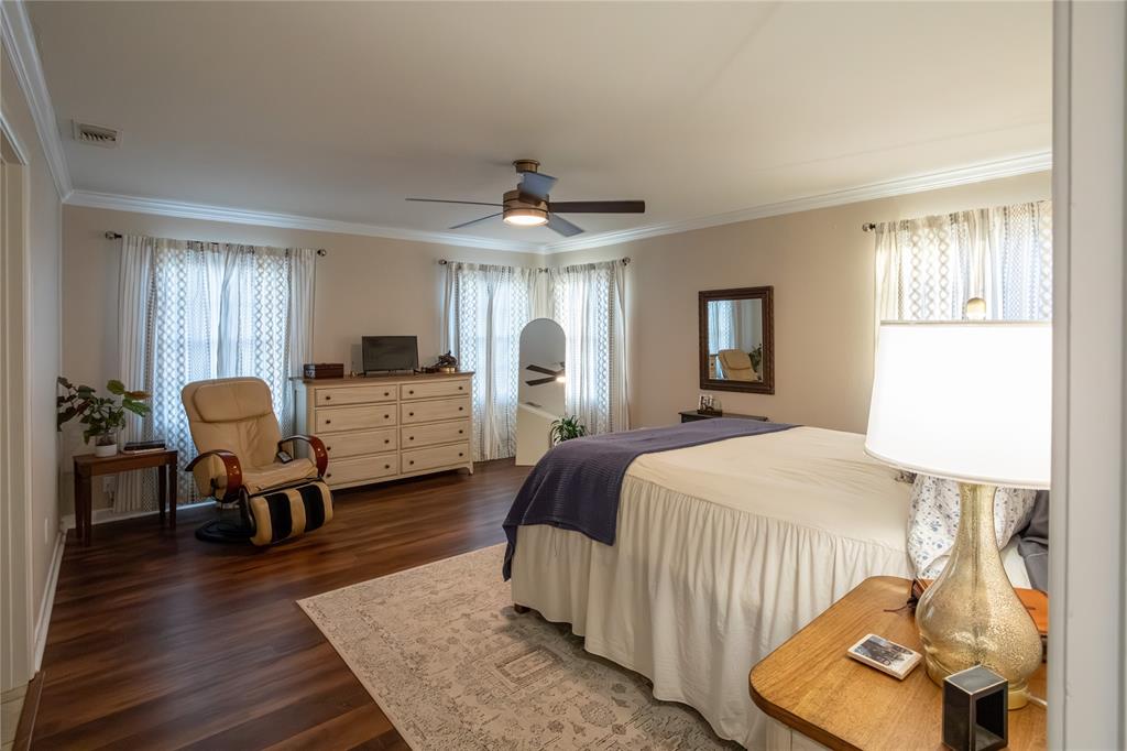 909 Cherry Street Baird, TX 79504 - Photo 20 of 32 a bedroom with a bed and wooden floor