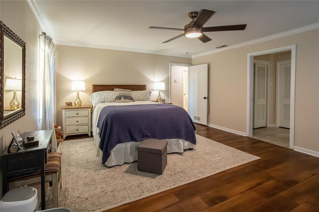 909 Cherry Street Baird, TX 79504 - Photo 21 of 32 a bedroom with a bed and wooden floor