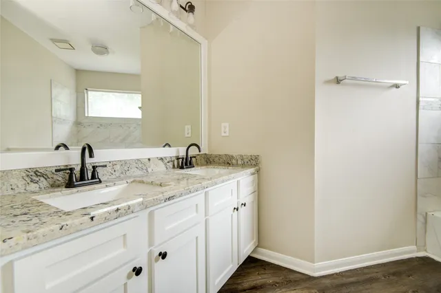 a bathroom with a granite countertop sink and a mirror