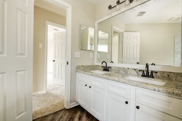 a bathroom with double sink and a mirror