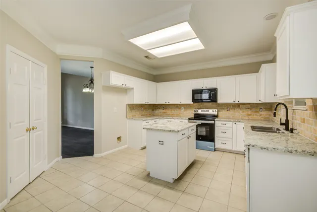 a kitchen with granite countertop white cabinets and white appliances
