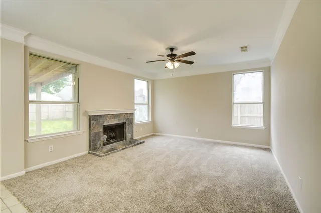 an empty room with windows and fireplace