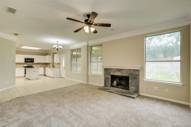 a view of an empty room with a fireplace and a window