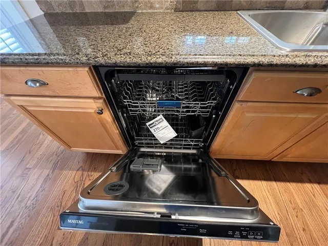 an empty room with wooden floor chandelier fan and windows