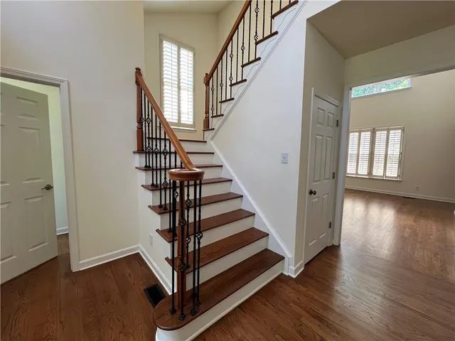 a view of a livingroom with wooden floor a fireplace and entryway