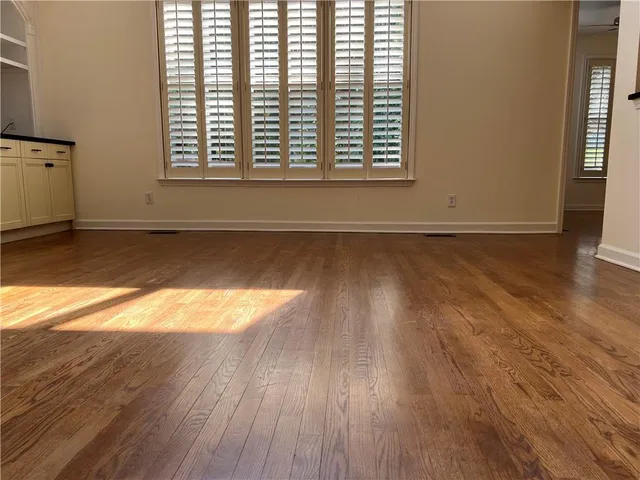 a large kitchen with stainless steel appliances granite countertop wooden cabinets a sink a stove a dining table and chairs