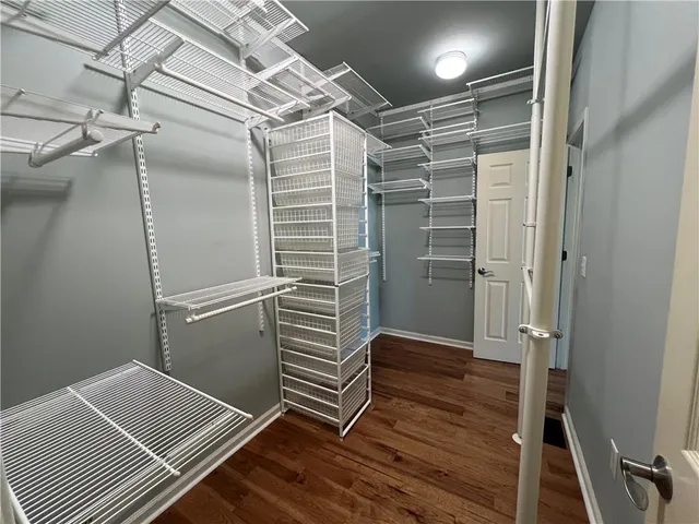 a room with walk in closet and wooden floor