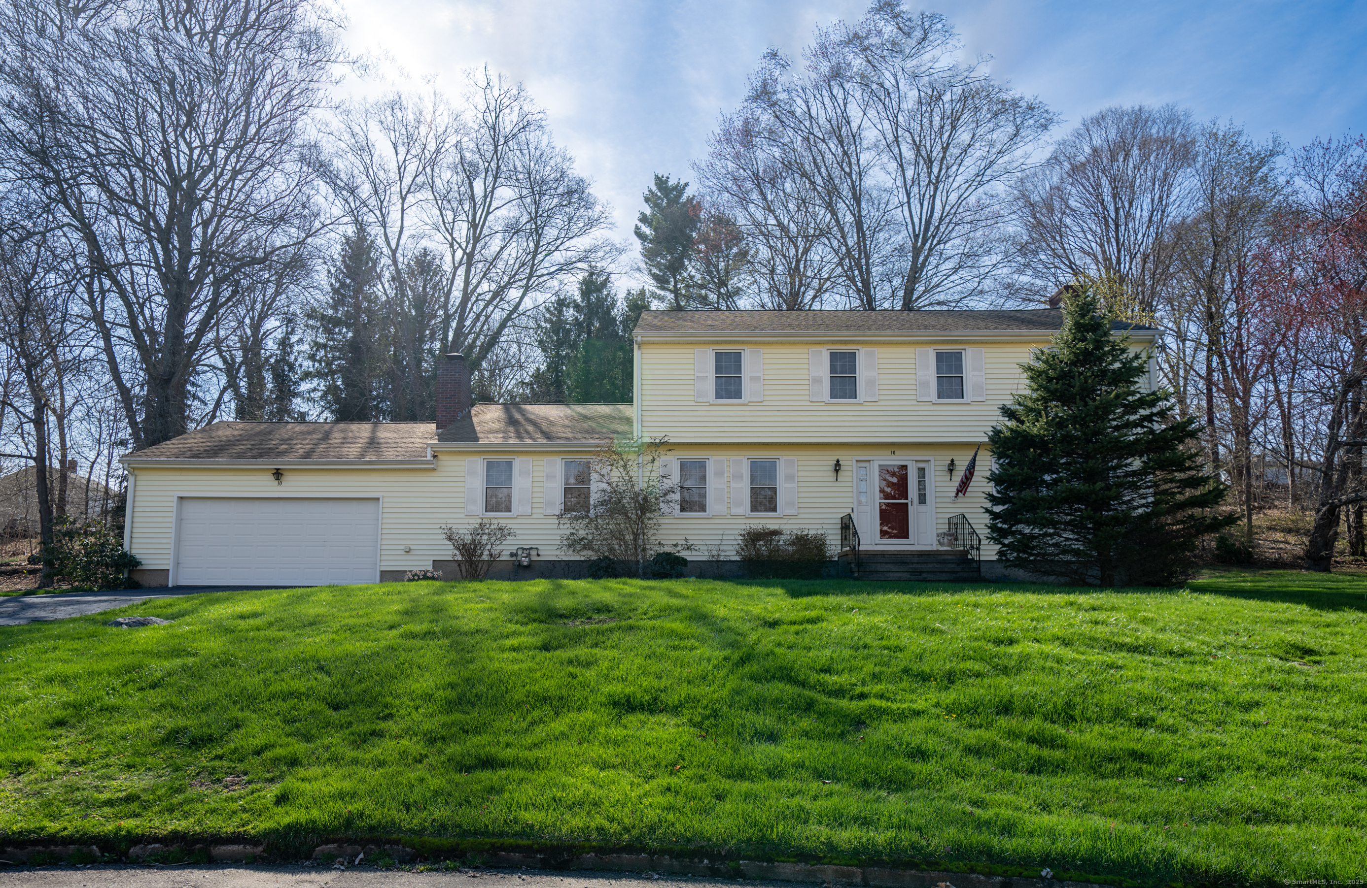 a view of a house with a big yard and large trees