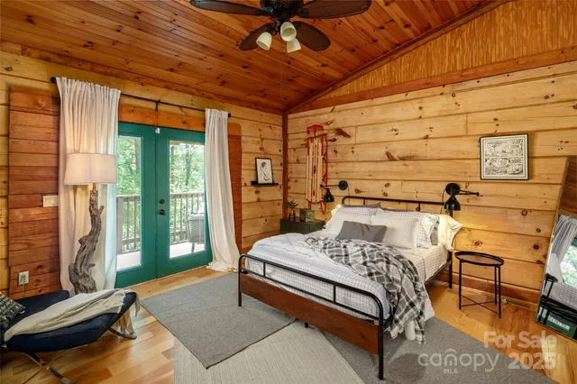 a bedroom with a bed a window and flat screen tv